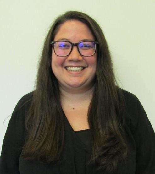 Doctoral Intern Kaitlyn Vilkin smiling at the camera wearing a black blouse in front of a white background